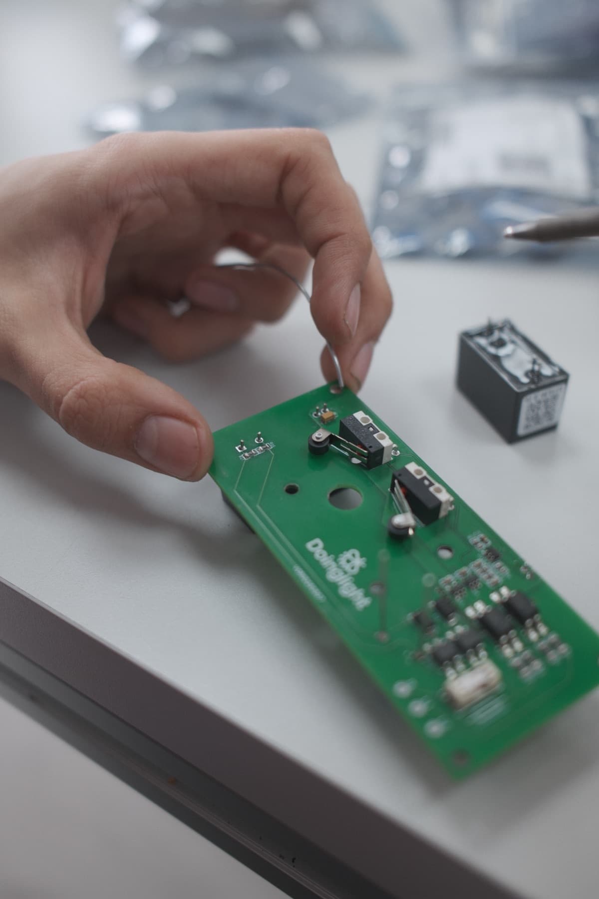 Manos sosteniendo una placa de circuito impreso terminada en el taller de DCMI